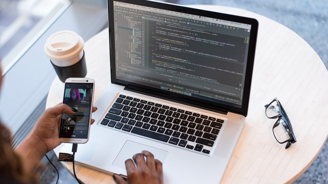 Developer testing the same cross-platform mobile app on an Android phone and an iPhone side by side