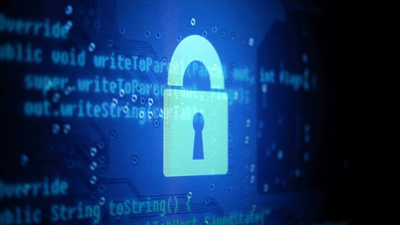 Developer reviewing code on a laptop with a padlock icon representing web application security